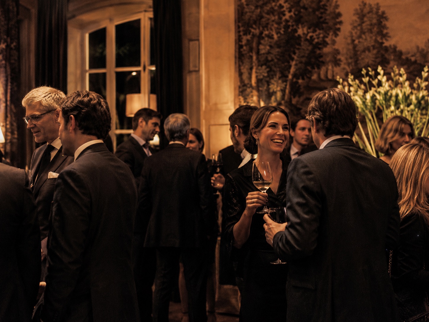 Invités en conversation lors d’une réception dans un hôtel particulier